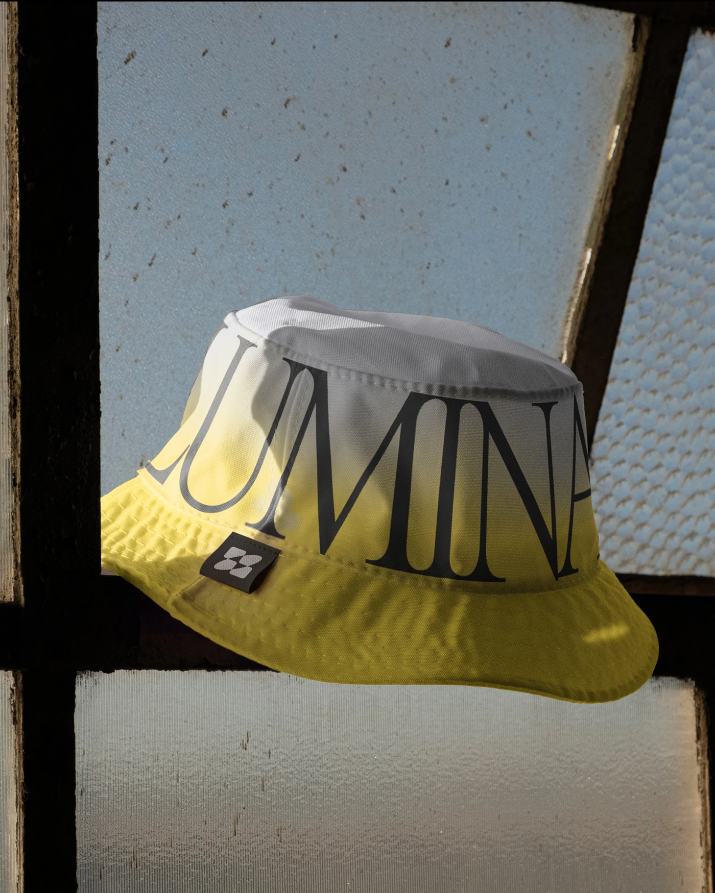 Luminar branded bucket hat merch — yellow gradient with serif logotype